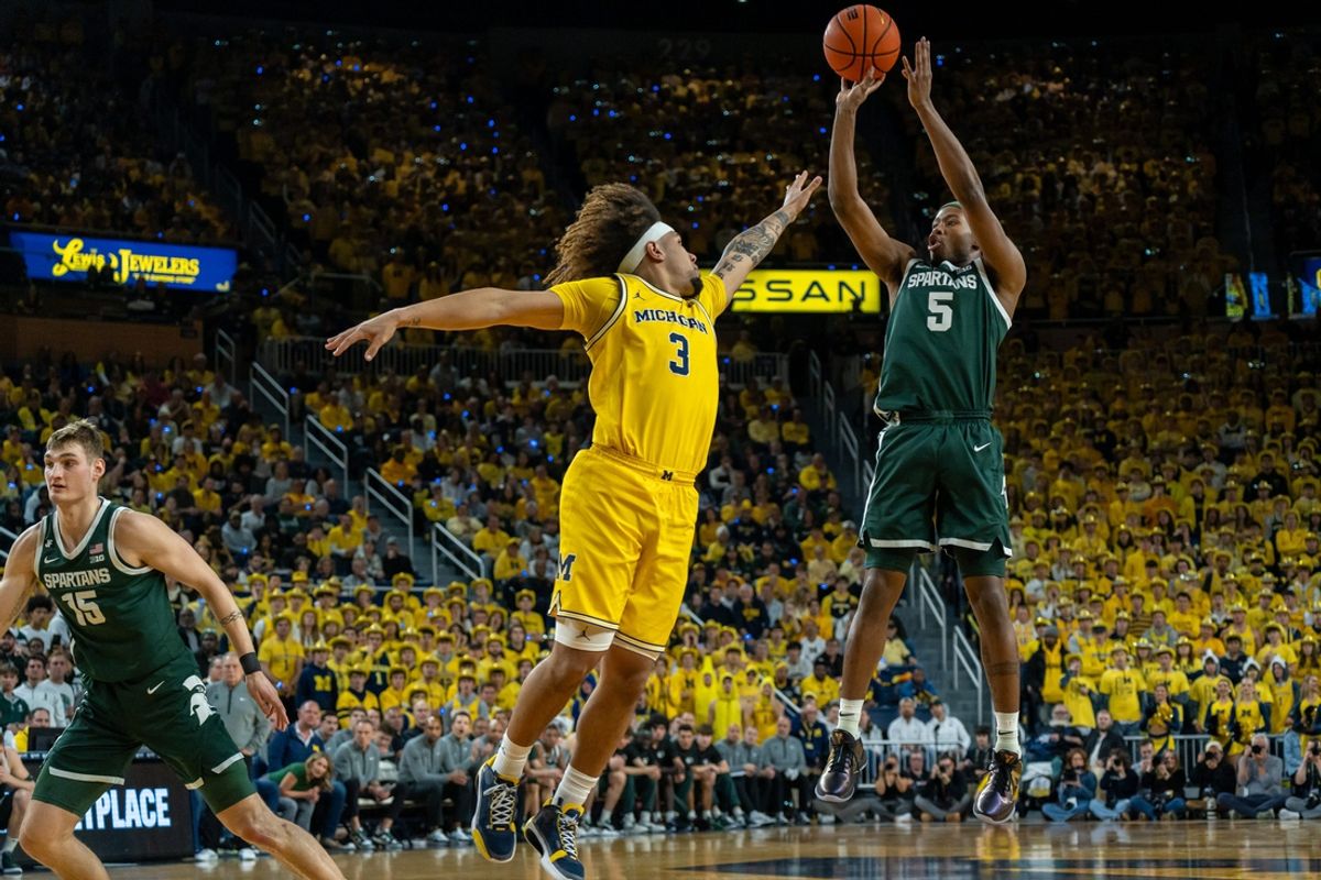 Feb 21, 2025; Ann Arbor, MI, USA; Michigan State player Tre Holloman (5) shoots over Michigan player Tre Donaldson (3) during the first half of their matchup at Crisler Center. Mandatory Credit: David Rodriguez Munoz-Imagn Images