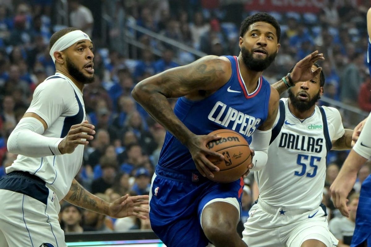 Apr 21, 2024; Los Angeles, California, USA; Los Angeles Clippers forward Paul George (13) drives past Dallas Mavericks center Daniel Gafford (21) and forward Derrick Jones Jr. (55) in the first quarter at Crypto.com Arena.