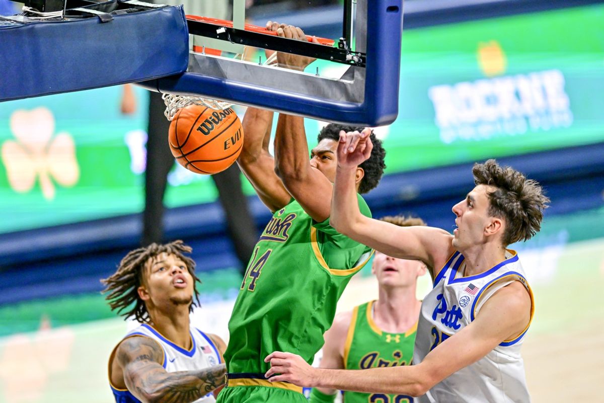 Feb 22, 2025; South Bend, Indiana, USA; Notre Dame Fighting Irish forward Kebba Njie (14) dunks as Pittsburgh Panthers forward Guillermo Diaz Graham (25) defends in the first half at the Purcell Pavilion. Mandatory Credit: Matt Cashore-Imagn Images