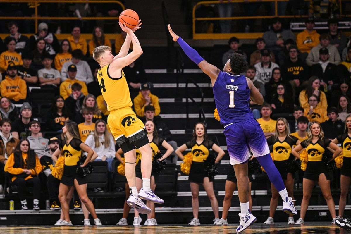 Feb 22, 2025; Iowa City, Iowa, USA; Iowa Hawkeyes guard Josh Dix (4) shoots the ball as Washington Huskies forward Great Osobor (1) defends during the first half at Carver-Hawkeye Arena. Mandatory Credit: Jeffrey Becker-Imagn Images