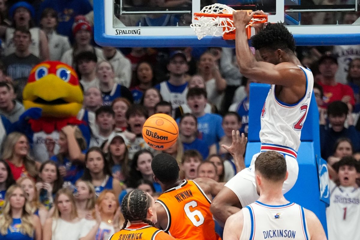 Feb 22, 2025; Lawrence, Kansas, USA; Kansas Jayhawks forward KJ Adams Jr. (24) dunks the ball as Oklahoma State Cowboys guard Brandon Newman (6) looks on during the first half at Allen Fieldhouse. Mandatory Credit: Denny Medley-Imagn Images