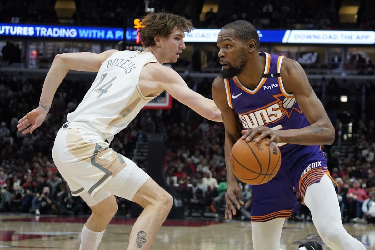 Feb 22, 2025; Chicago, Illinois, USA; Chicago Bulls forward Matas Buzelis (14) defends Phoenix Suns forward Kevin Durant (35) during the first quarter at United Center. Mandatory Credit: David Banks-Imagn Images