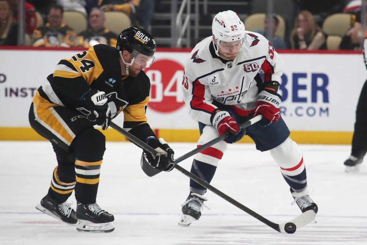 Feb 22, 2025; Pittsburgh, Pennsylvania, USA; Pittsburgh Penguins defenseman Matt Grzelcyk (24) moves the puck against Washington Capitals center Ethen Frank (53) during the third period at PPG Paints Arena. Mandatory Credit: Charles LeClaire-Imagn Images