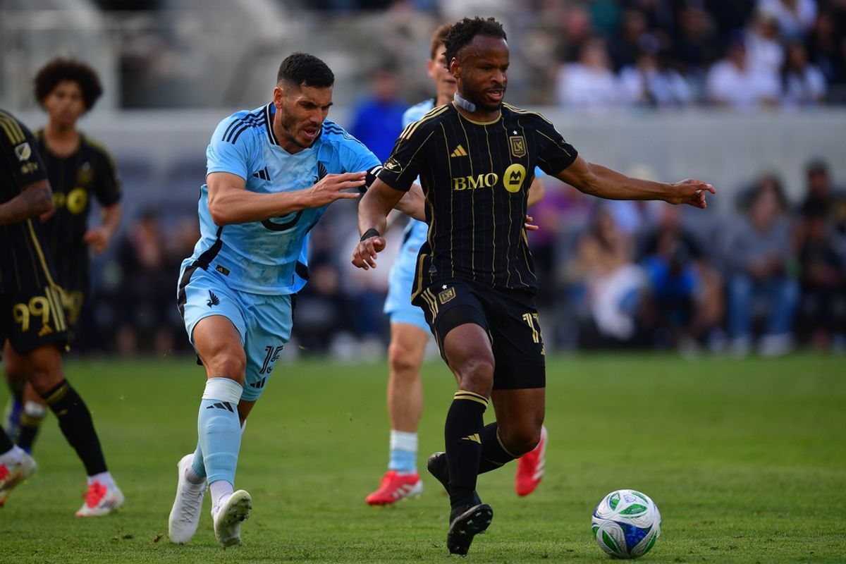 Feb 22, 2025; Los Angeles, California, USA; LAFC forward Jeremy Ebobisse (17) kicks the ball past Minnesota United midfielder Michael Boxall (15) during the second half at BMO Stadium. Mandatory Credit: Gary A. Vasquez-Imagn Images