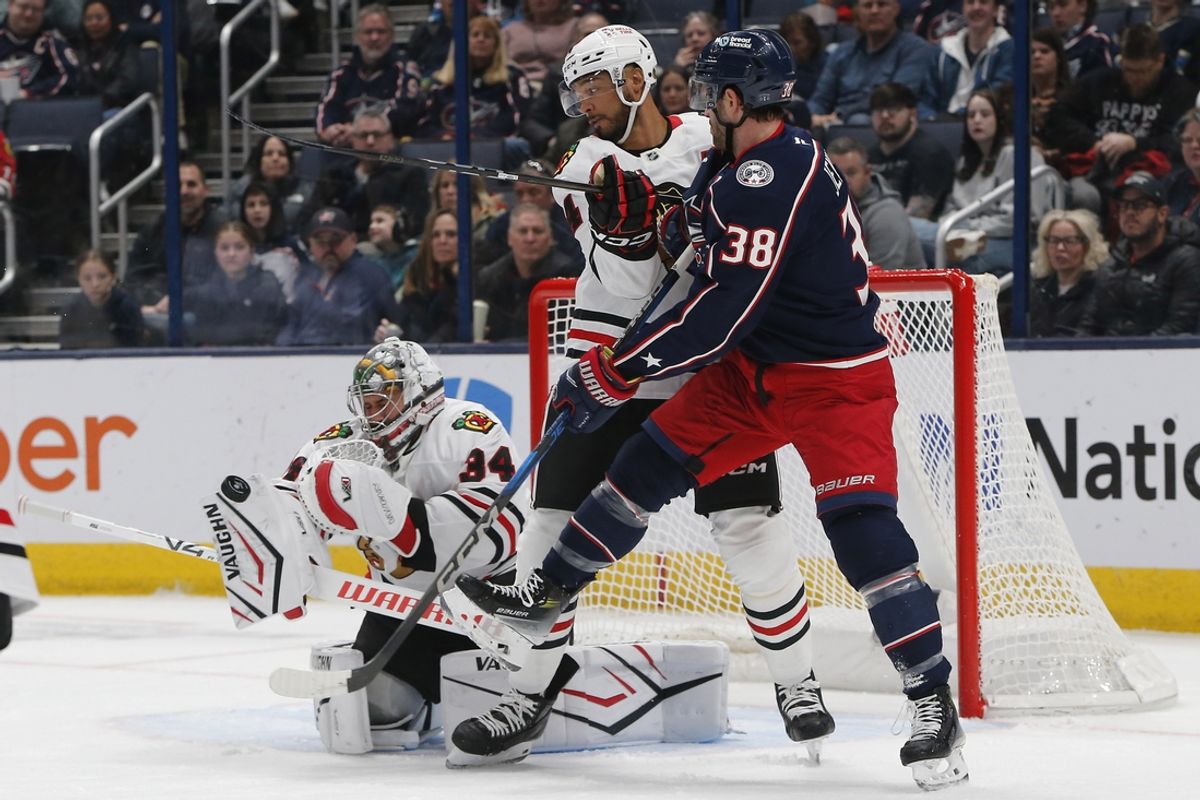Feb 22, 2025; Columbus, Ohio, USA; Chicago Blackhawks goalie Petr Mrazek (34) makes a blocker save as Columbus Blue Jackets center Boone Jenner (38) looks for a rebound during the first period at Nationwide Arena. Mandatory Credit: Russell LaBounty-Imagn Images