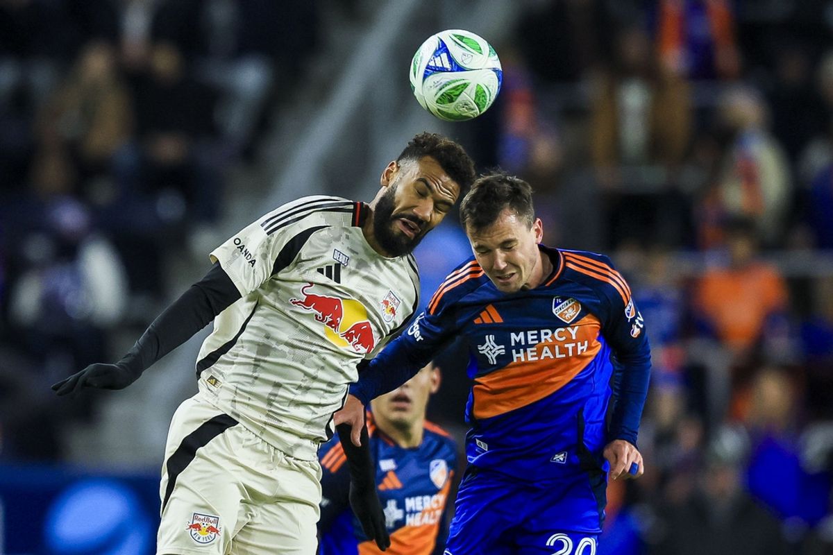 Feb 22, 2025; Cincinnati, Ohio, USA; New York Red Bulls forward Eric Maxim Choupo-Moting (13) heads the ball against FC Cincinnati midfielder Pavel Bucha (20) in the first half at TQL Stadium. Mandatory Credit: Katie Stratman-Imagn Images