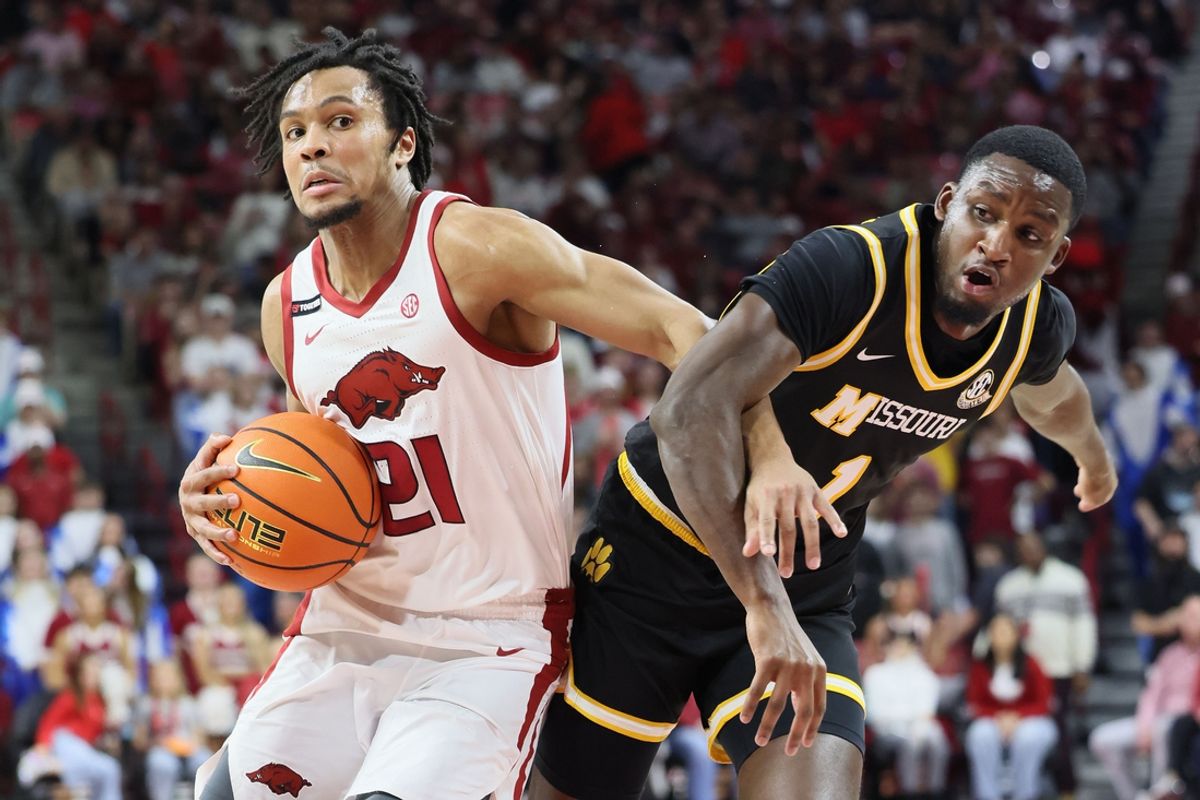 Feb 22, 2025; Fayetteville, Arkansas, USA; Arkansas Razorbacks guard D.J. Wagner (21) drives against Missouri Tigers guard Marques Warrick (1) during the first half at Bud Walton Arena. Mandatory Credit: Nelson Chenault-Imagn Images