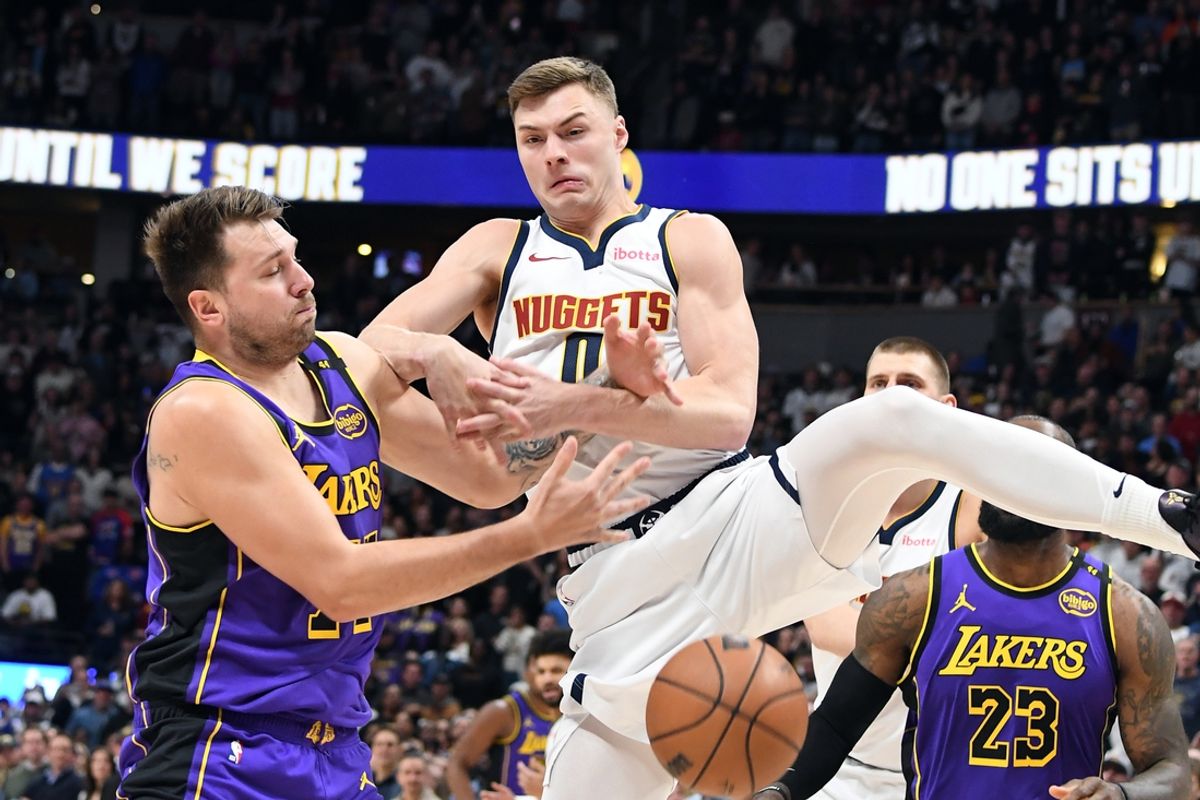 Feb 22, 2025; Denver, Colorado, USA; Denver Nuggets guard Christian Braun (0) has the ball knocked away by Los Angeles Lakers guard Luka Doncic (77) during the first half at Ball Arena. Mandatory Credit: Christopher Hanewinckel-Imagn Images