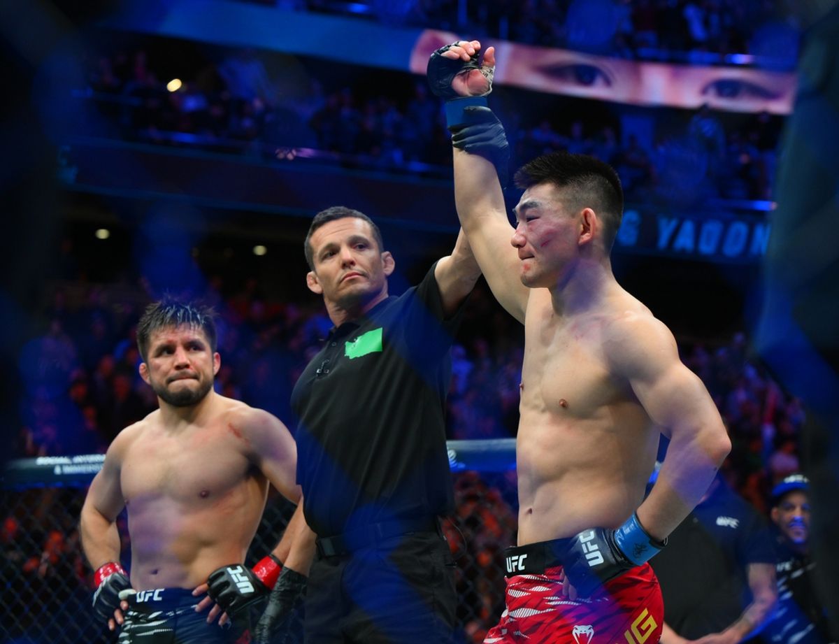 Feb 22, 2025; Seattle, Washington, USA; Song Yadong (blue gloves) celebrates after defeating Henry Cejudo (red gloves) in the bantamweight bout during UFC Fight Night at Climate Pledge Arena. Mandatory Credit: Steven Bisig-Imagn Images