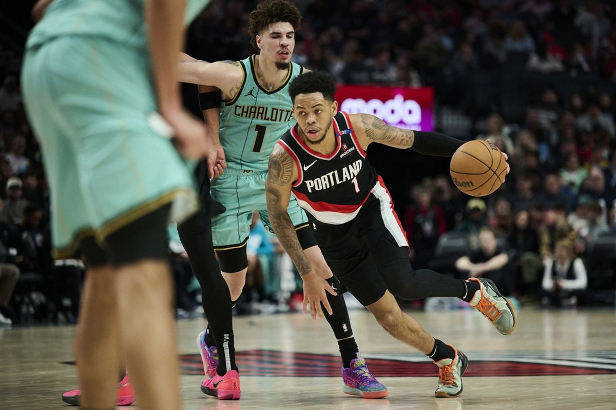 Feb 22, 2025; Portland, Oregon, USA; Portland Trail Blazers guard Anfernee Simons (1) drives past Charlotte Hornets guard LaMelo Ball (1) during the second half against at Moda Center. Mandatory Credit: Troy Wayrynen-Imagn Images