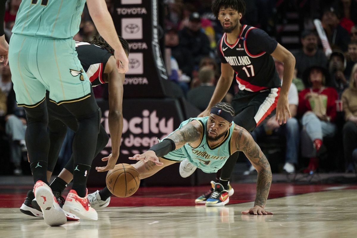 Feb 22, 2025; Portland, Oregon, USA; Charlotte Hornets forward Miles Bridges (0) dives for a lose ball during the second half against Portland Trail Blazers forward Jabari Walker (34) at Moda Center. Mandatory Credit: Troy Wayrynen-Imagn Images