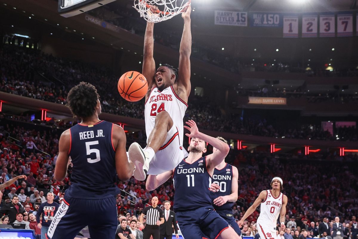 Feb 23, 2025; New York, New York, USA;  St. John's Red Storm forward Zuby Ejiofor (24) dunks past Connecticut Huskies forward Alex Karaban (11) in the second half at Madison Square Garden. Mandatory Credit: Wendell Cruz-Imagn Images