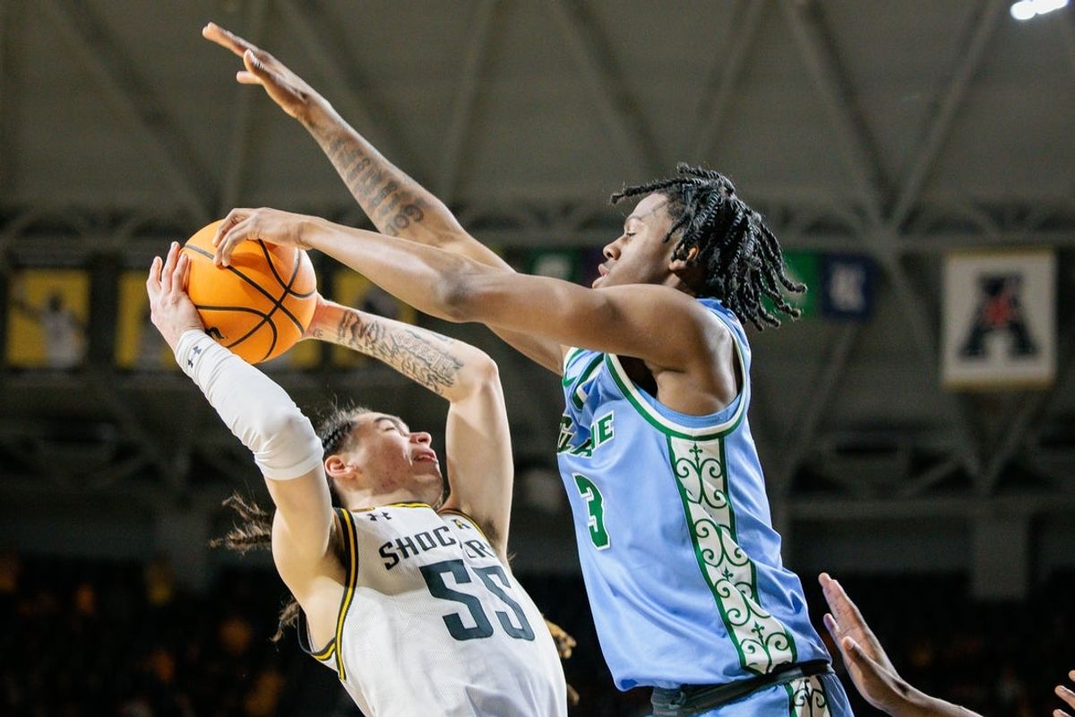 Feb 23, 2025; Wichita, Kansas, USA; Wichita State Shockers guard Bijan Cortes (55) shoots the ball around Tulane Green Wave guard Kam Williams (3) during the second half at Charles Koch Arena. Mandatory Credit: William Purnell-Imagn Images