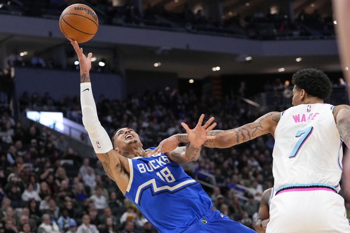 Feb 23, 2025; Milwaukee, Wisconsin, USA;  Milwaukee Bucks forward Kyle Kuzma (18) shoots around Miami Heat center Kel'el Ware (7) during the first quarter at Fiserv Forum. Mandatory Credit: Jeff Hanisch-Imagn Images