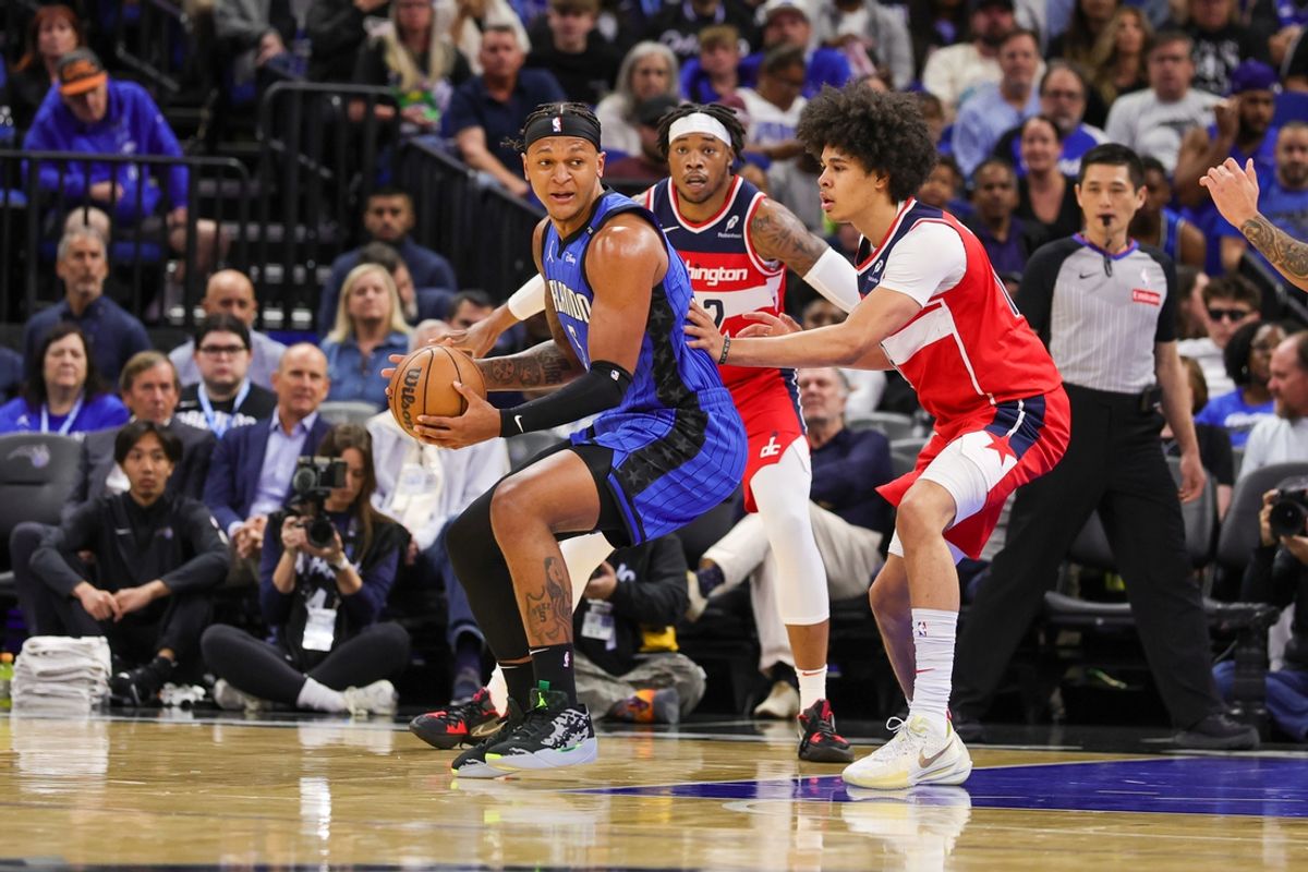 Feb 23, 2025; Orlando, Florida, USA; Orlando Magic forward Paolo Banchero (5) moves the ball against Washington Wizards forward Kyshawn George (18) during the first quarter at Kia Center. Mandatory Credit: Mike Watters-Imagn Images