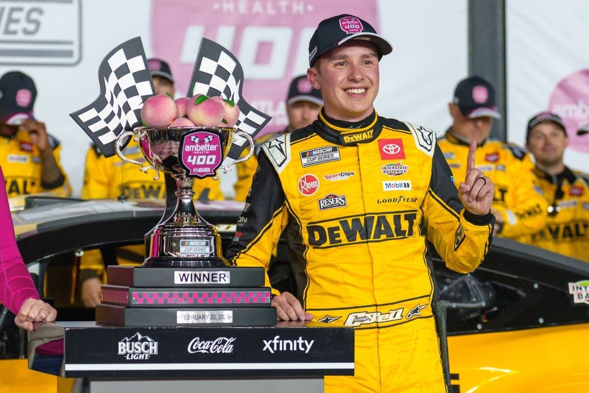 Feb 23, 2025; Hampton, Georgia, USA; Christopher Bell (20) poses with his trophy in Victory Lane after claiming a victory at Atlanta Motor Speedway. Mandatory Credit: Jason Allen-Imagn Images