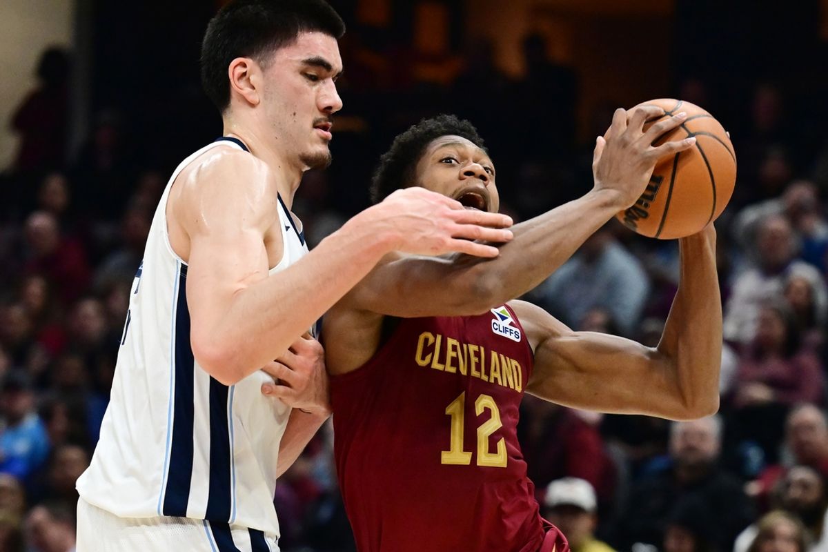 Feb 23, 2025; Cleveland, Ohio, USA; Cleveland Cavaliers forward De'Andre Hunter (12) drives to the basket against Memphis Grizzlies center Zach Edey (14) during the first half at Rocket Arena. Mandatory Credit: Ken Blaze-Imagn Images