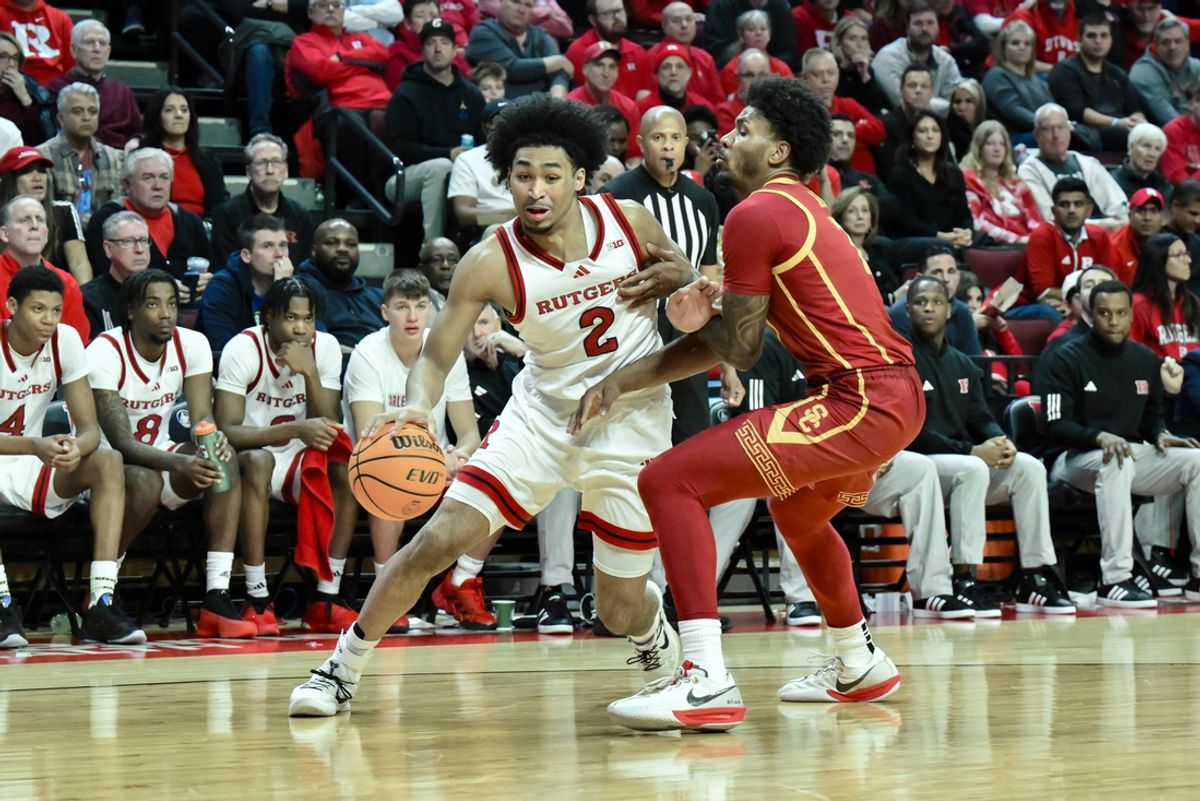 Feb 23, 2025; Piscataway, New Jersey, USA; Rutgers Scarlet Knights guard Dylan Harper (2) drives past USC Trojans guard Chibuzo Agbo (7) during the second half at Jersey Mike's Arena. Mandatory Credit: John Jones-Imagn Images