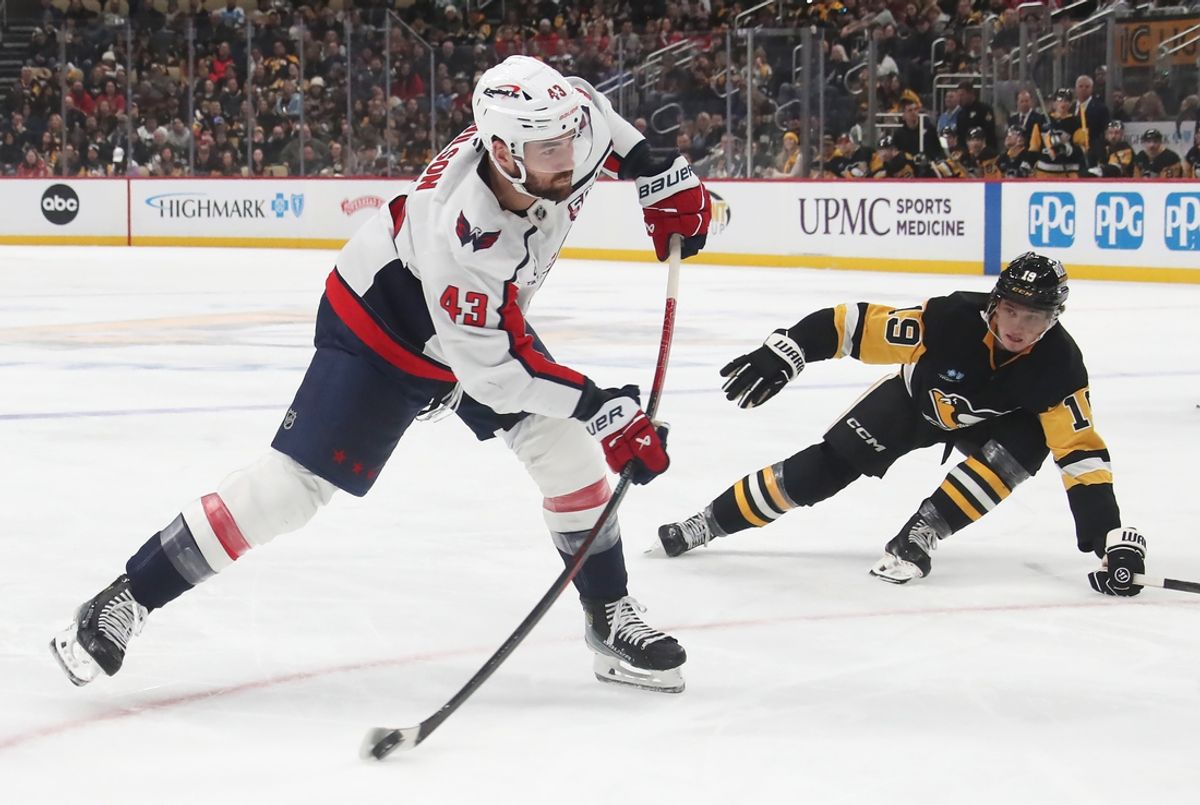 Feb 22, 2025; Pittsburgh, Pennsylvania, USA;  Washington Capitals right wing Tom Wilson (43) shoots the puck as Pittsburgh Penguins center Cody Glass (19) defends during the second period at PPG Paints Arena. Mandatory Credit: Charles LeClaire-Imagn Images