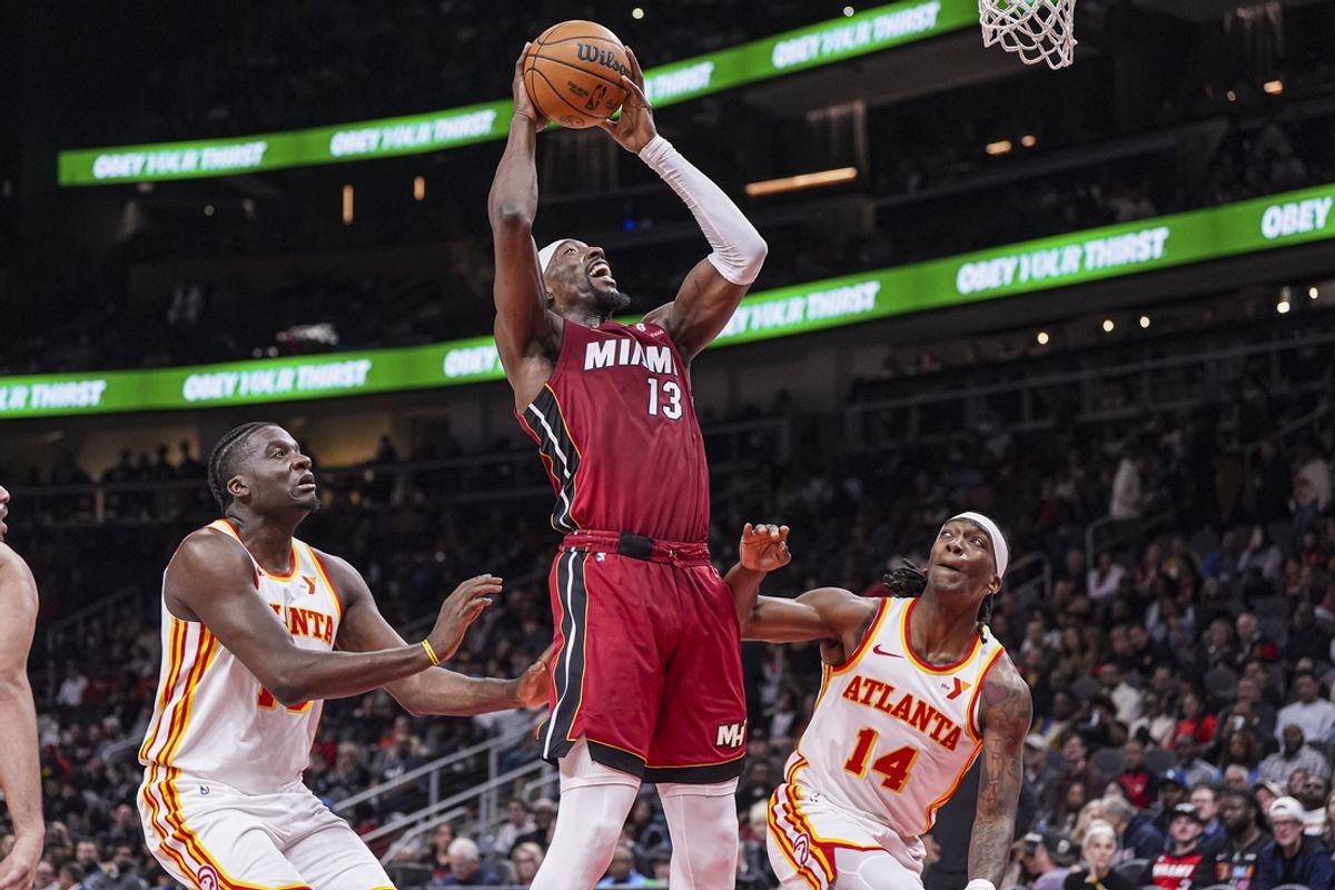 Feb 24, 2025; Atlanta, Georgia, USA; Miami Heat center Bam Adebayo (13) goes to the basket between Atlanta Hawks center Clint Capela (15) and guard Terance Mann (14) during the first half at State Farm Arena. Mandatory Credit: Dale Zanine-Imagn Images