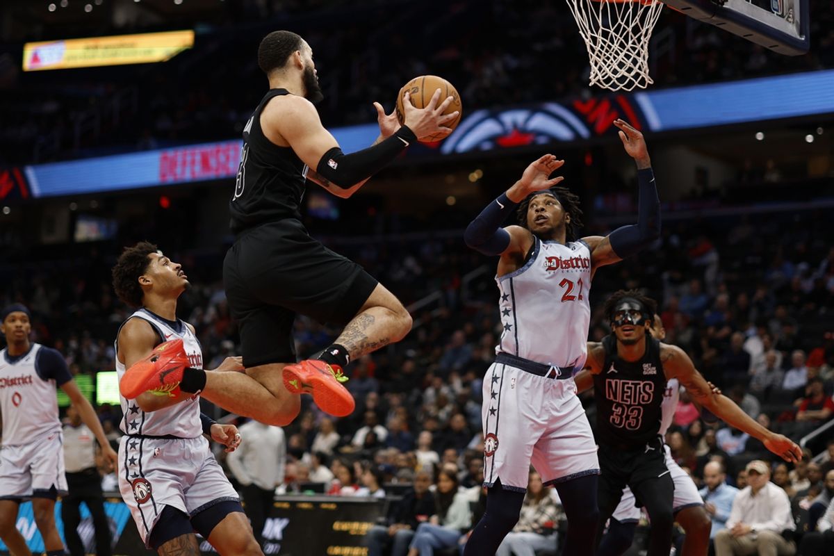 Feb 24, 2025; Washington, District of Columbia, USA; Brooklyn Nets guard Tyrese Martin (13) leaps to pass the ball as Washington Wizards forward Richaun Holmes (22) defends in the first half at Capital One Arena. Mandatory Credit: Geoff Burke-Imagn Images