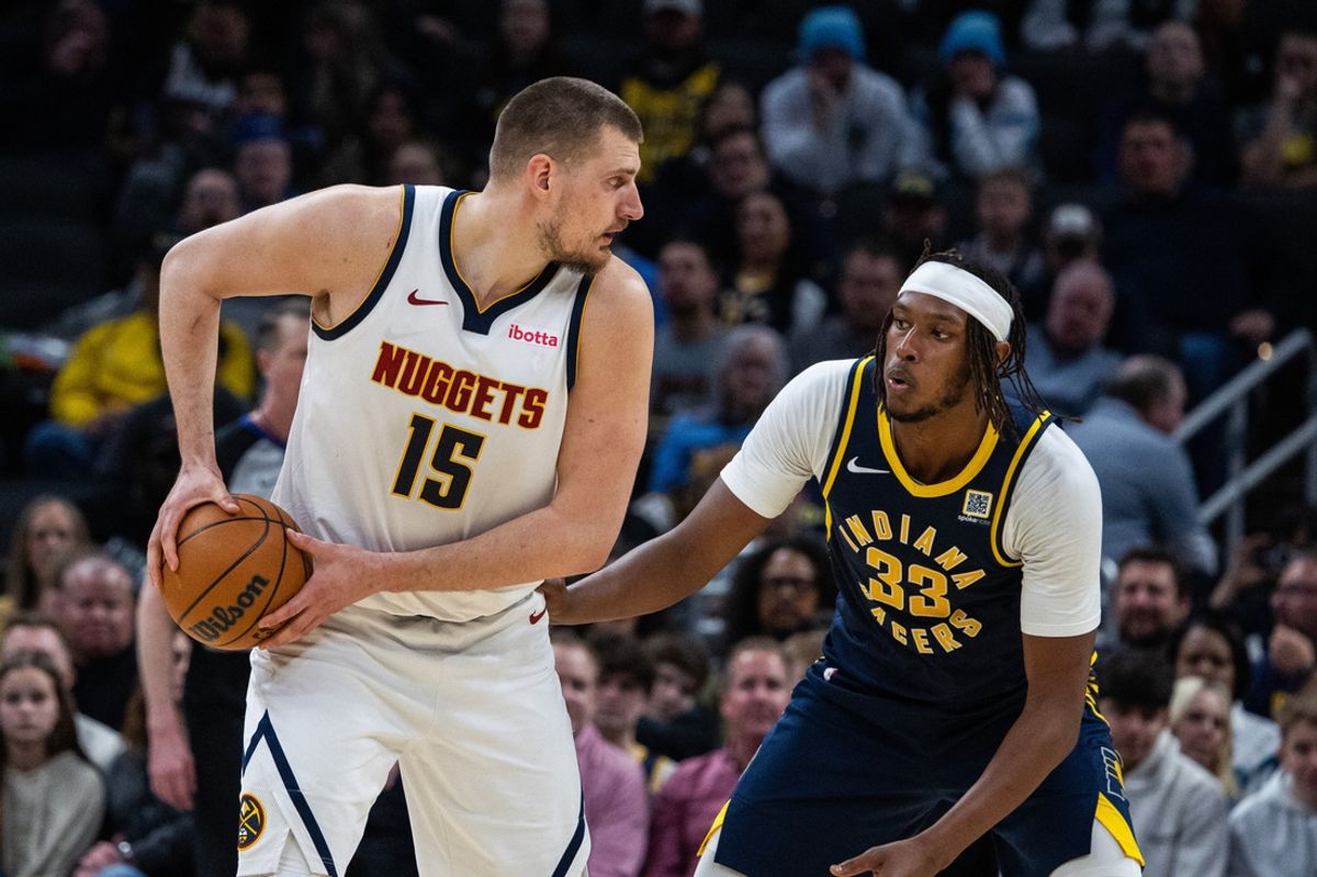 Feb 24, 2025; Indianapolis, Indiana, USA; Denver Nuggets center Nikola Jokic (15) holds the ball while Indiana Pacers center Myles Turner (33) defends in the first half at Gainbridge Fieldhouse. Mandatory Credit: Trevor Ruszkowski-Imagn Images