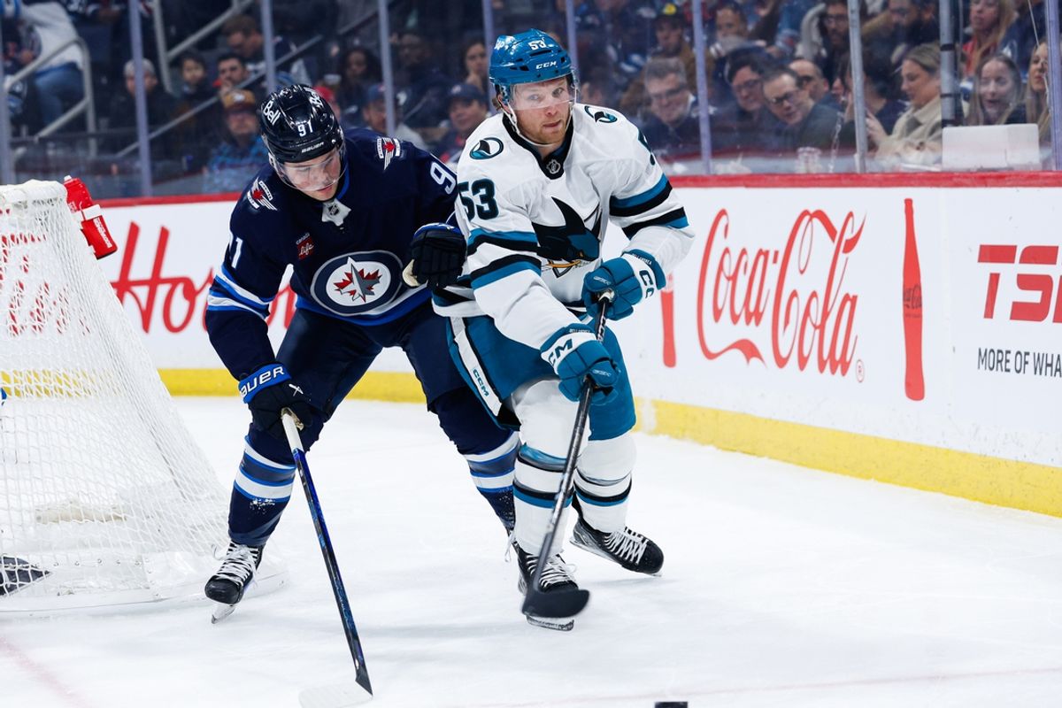Feb 24, 2025; Winnipeg, Manitoba, CAN;  San Jose Sharks forward Ty Dellandrea (53) and Winnipeg Jets forward Cole Perfetti (91) battle for the puck during the first period at Canada Life Centre. Mandatory Credit: Terrence Lee-Imagn Images