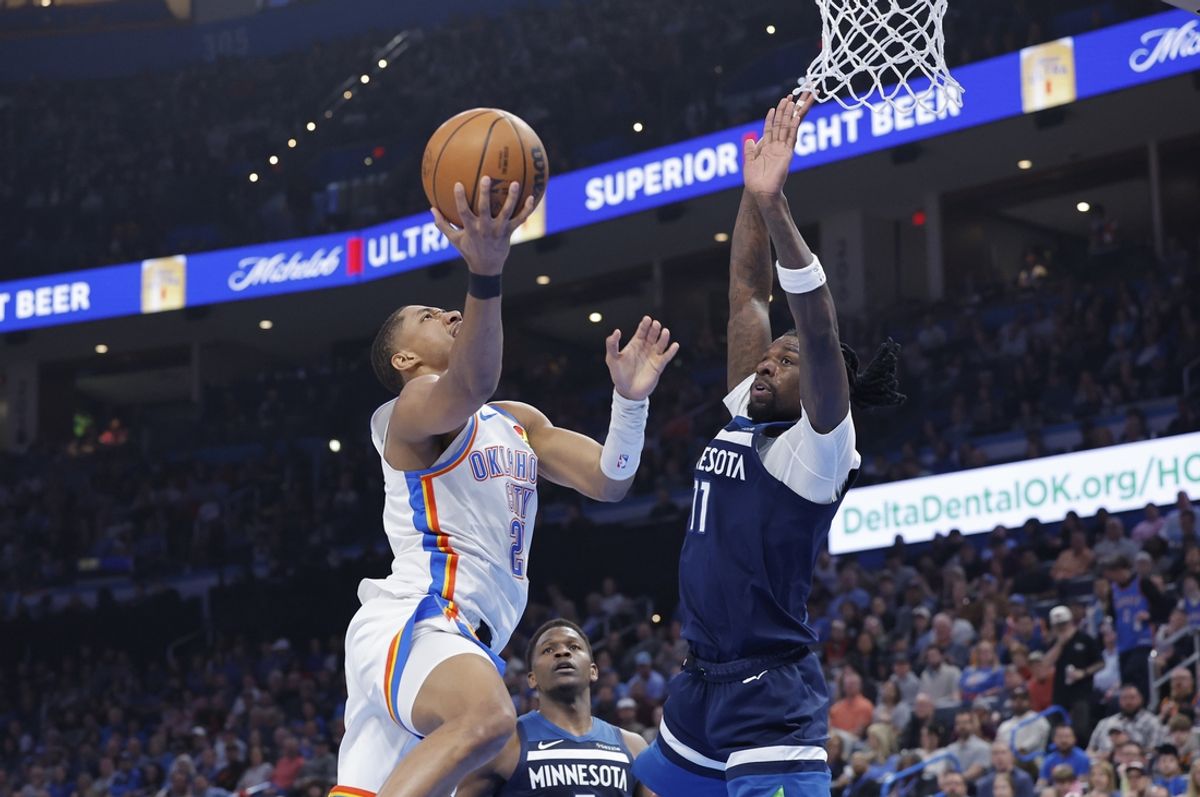 Feb 24, 2025; Oklahoma City, Oklahoma, USA; Oklahoma City Thunder guard Aaron Wiggins (21) goes to the basket as Minnesota Timberwolves center Naz Reid (11) defends during the second quarter at Paycom Center. Mandatory Credit: Alonzo Adams-Imagn Images