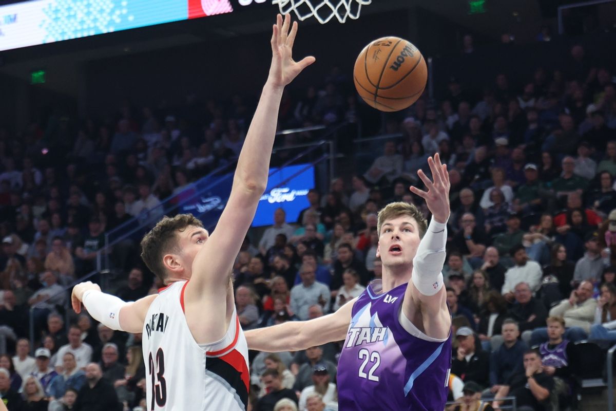Feb 24, 2025; Salt Lake City, Utah, USA; Utah Jazz forward Kyle Filipowski (22) lays the ball up against Portland Trail Blazers center Donovan Clingan (23) during the first half at Delta Center. Mandatory Credit: Rob Gray-Imagn Images
