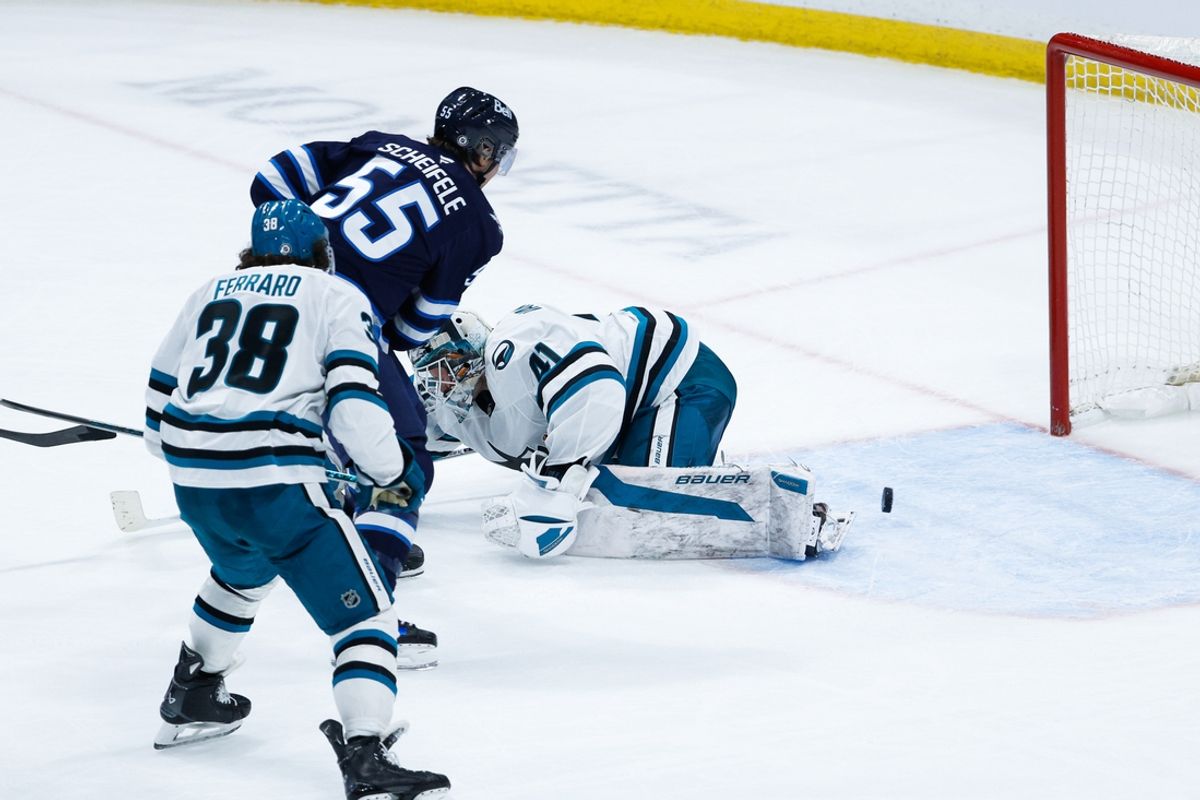 Feb 24, 2025; Winnipeg, Manitoba, CAN;  Winnipeg Jets forward Mark Scheifele (55) scores on San Jose Sharks goalie Vitek Vanecek (41) during the overtime period at Canada Life Centre. Mandatory Credit: Terrence Lee-Imagn Images