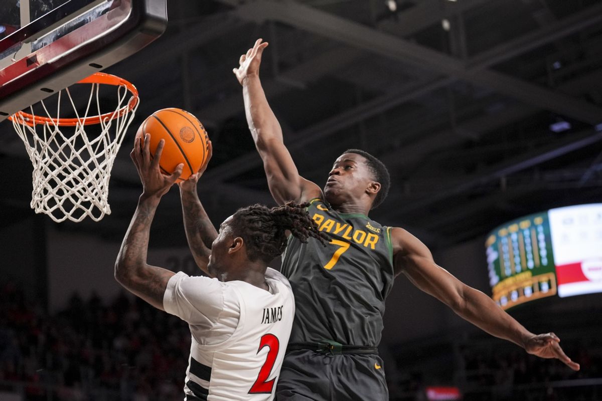 Feb 25, 2025; Cincinnati, Ohio, USA;  Cincinnati Bearcats guard Jizzle James (2) drives to the basket against Baylor Bears guard VJ Edgecombe (7) in the first half at Fifth Third Arena. Mandatory Credit: Aaron Doster-Imagn Images