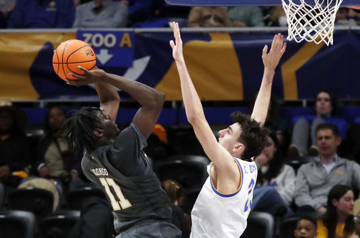 Feb 25, 2025; Pittsburgh, Pennsylvania, USA;  Georgia Tech Yellow Jackets forward Baye Ndongo (11) shoots against Pittsburgh Panthers forward Guillermo Diaz Graham (25) during the first half at the Petersen Events Center. Mandatory Credit: Charles LeClaire-Imagn Images