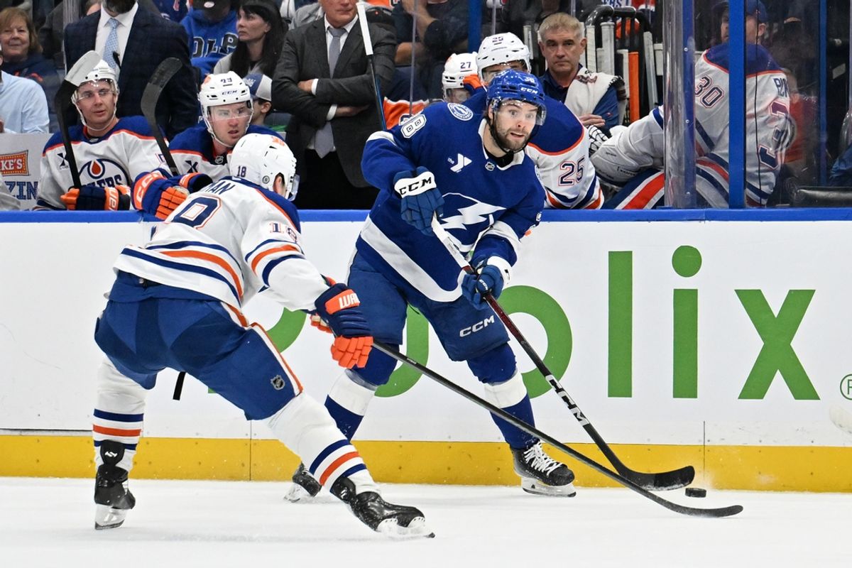 Feb 25, 2025; Tampa, Florida, USA ; Tampa Bay Lightning left wing Brandon Hagel (38) gets the puck past Edmonton Oilers center Adam Henrique (19) in the first period  at Amalie Arena. Mandatory Credit: Jonathan Dyer-Imagn Images