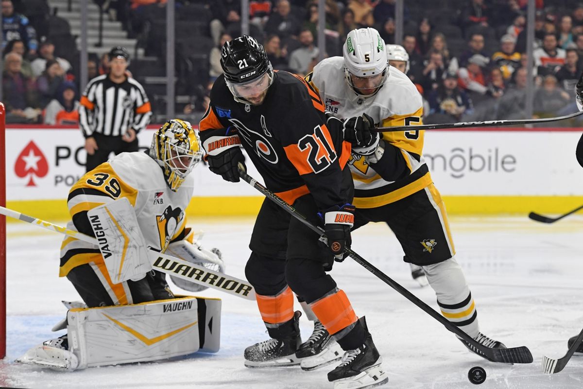Feb 25, 2025; Philadelphia, Pennsylvania, USA; Philadelphia Flyers center Scott Laughton (21) battle for the puck with Pittsburgh Penguins defenseman Ryan Shea (5) in front of goaltender Alex Nedeljkovic (39) during the second period at Wells Fargo Center. Mandatory Credit: Eric Hartline-Imagn Images