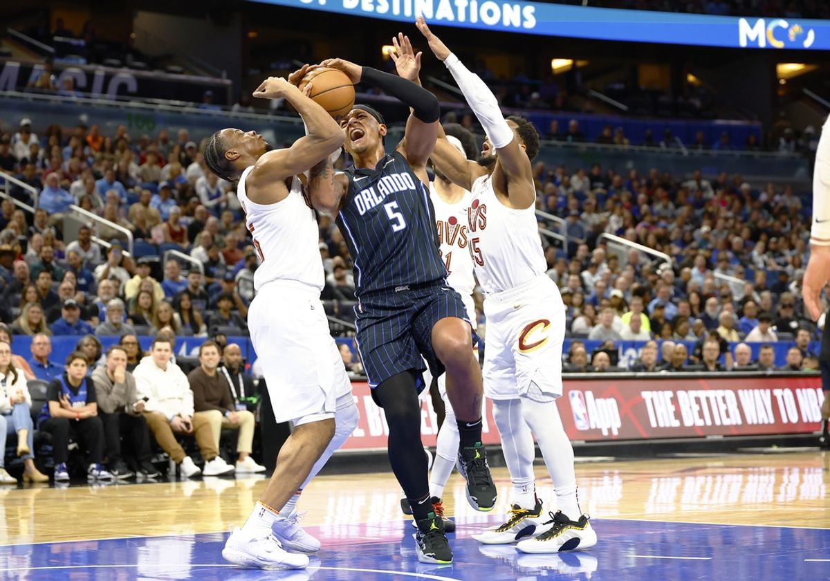 Feb 25, 2025; Orlando, Florida, USA;  Orlando Magic forward Paolo Banchero (5) tries to get off a shot against the Cleveland Cavaliers during the first half at Kia Center. Mandatory Credit: Russell Lansford-Imagn Images