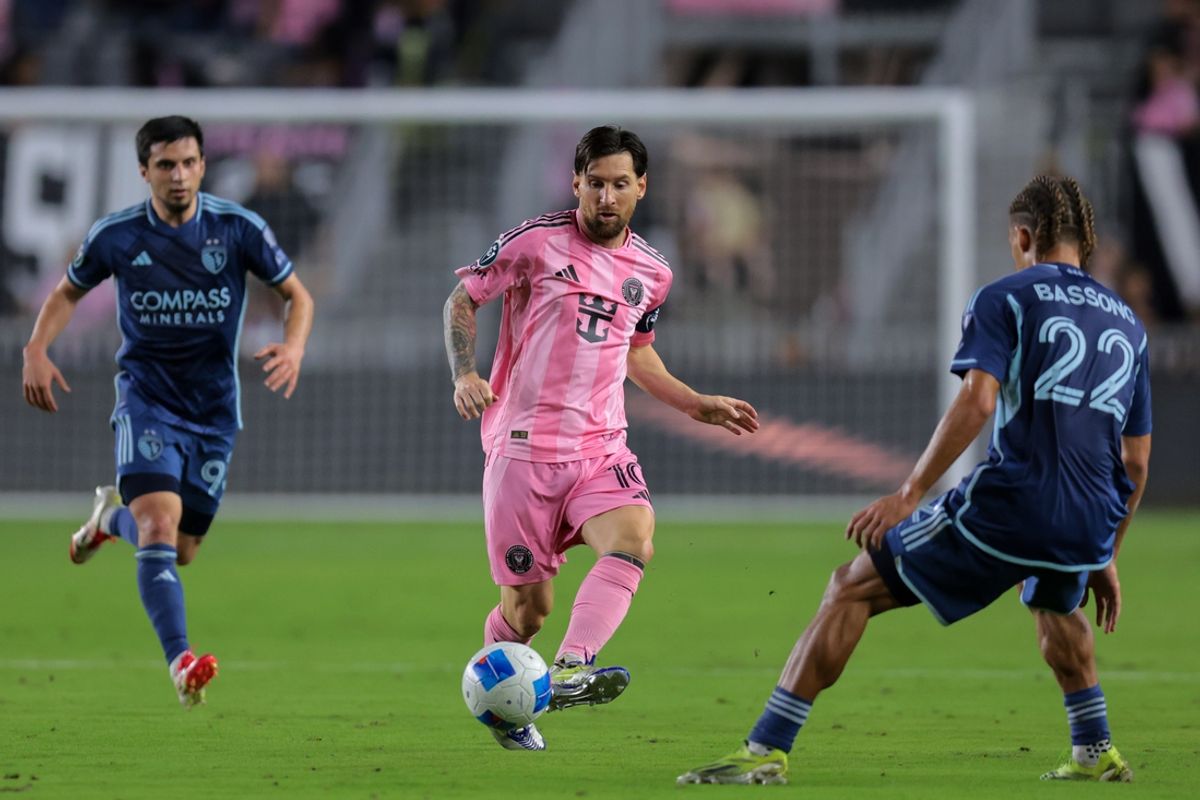 Feb 25, 2025; Fort Lauderdale, Florida, USA; Inter Miami CF forward Lionel Messi (10) passes the ball as Sporting Kansas City defender Zorhan Bassong (22) defends during the first half in Round One of the 2025 Concacaf Champions Cup at Chase Stadium. Mandatory Credit: Sam Navarro-Imagn Images
