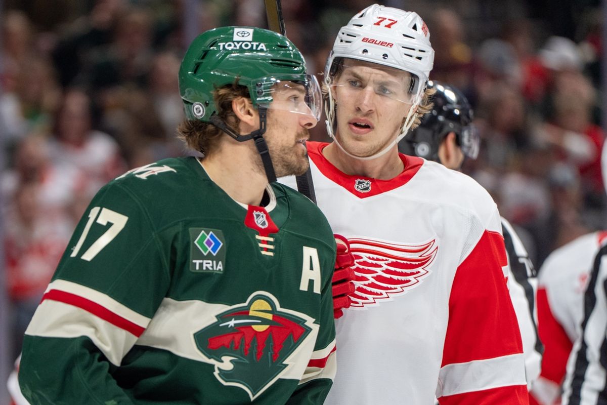 Feb 25, 2025; Saint Paul, Minnesota, USA; Detroit Red Wings defenseman Simon Edvinsson (77) and Minnesota Wild left wing Marcus Foligno (17) exchange words during a stoppage in the second period at Xcel Energy Center. Mandatory Credit: Matt Blewett-Imagn Images