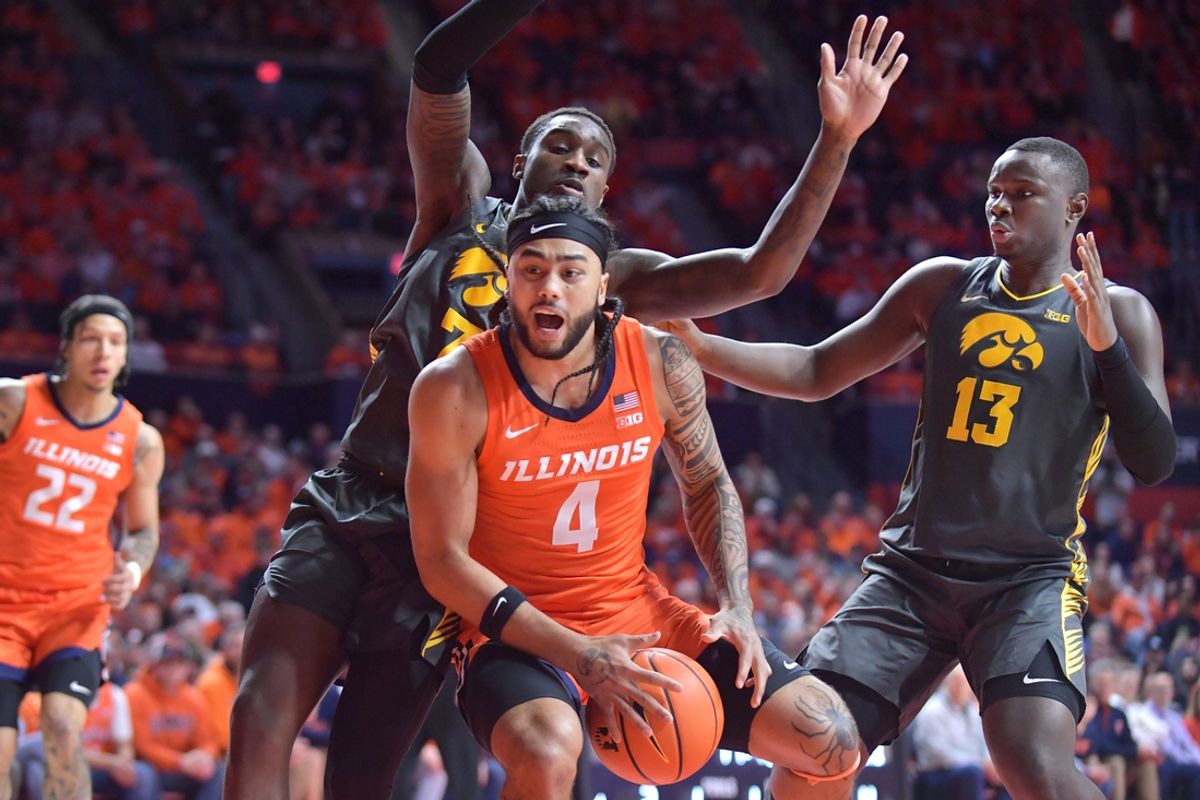 Feb 25, 2025; Champaign, Illinois, USA;  Illinois Fighting Illini guard Kylan Boswell (4) drives to the basket as Iowa Hawkeyes forward Seydou Traore (7) pressures during the first half at State Farm Center. Mandatory Credit: Ron Johnson-Imagn Images