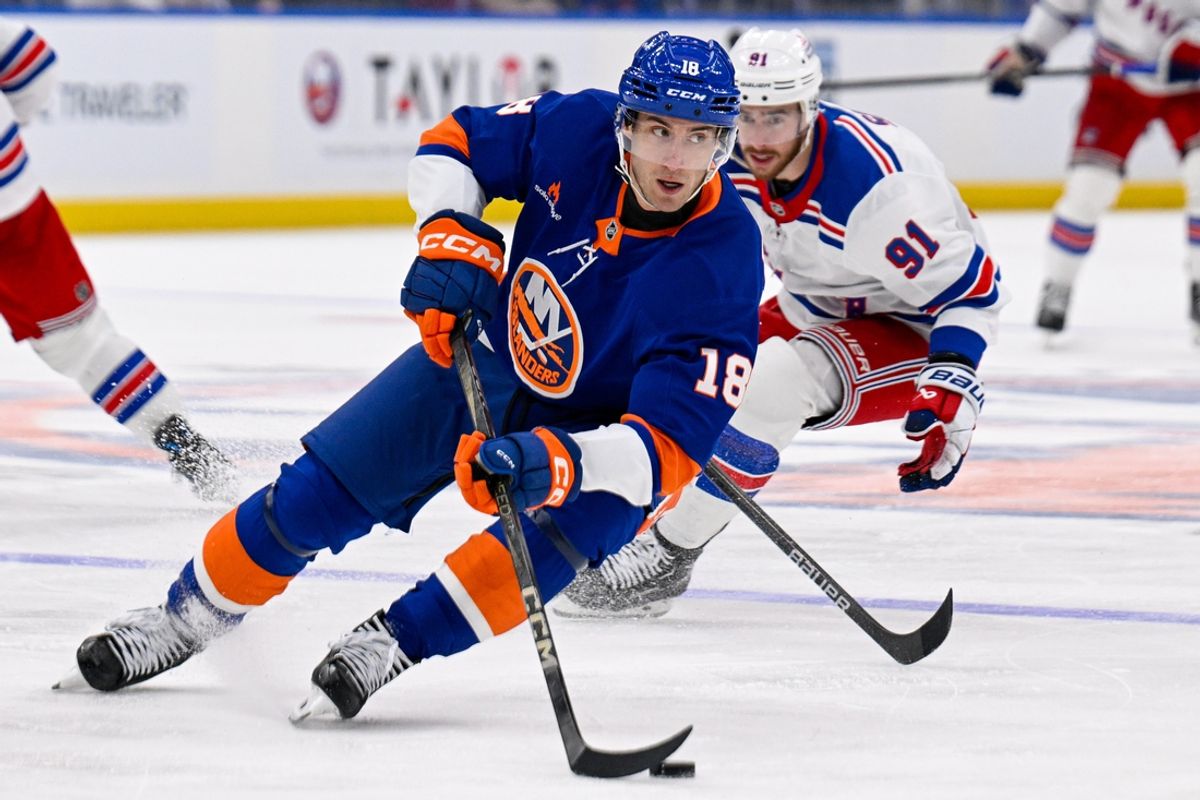 Feb 25, 2025; Elmont, New York, USA;  New York Islanders left wing Pierre Engvall (18) skates the puck against the New York Rangers during the third period at UBS Arena. Mandatory Credit: Dennis Schneidler-Imagn Images