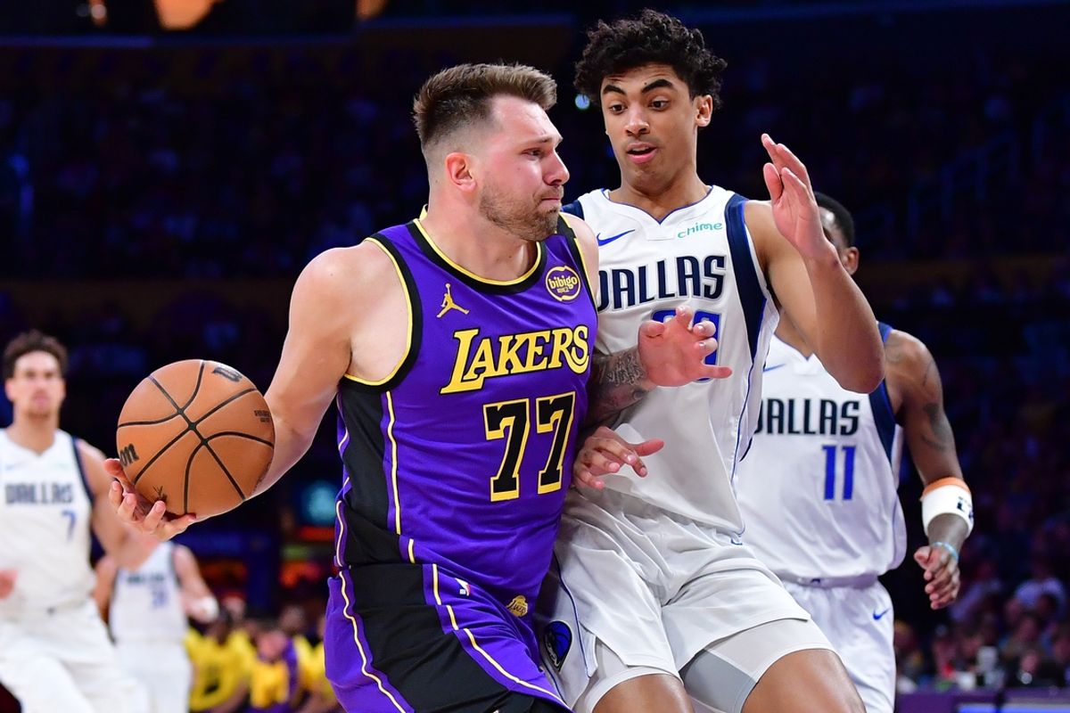 Feb 25, 2025; Los Angeles, California, USA; Los Angeles Lakers guard Luka Doncic (77) dribbles the ball Dallas Mavericks guard Max Christie (00) during the second half at Crypto.com Arena. Mandatory Credit: Gary A. Vasquez-Imagn Images