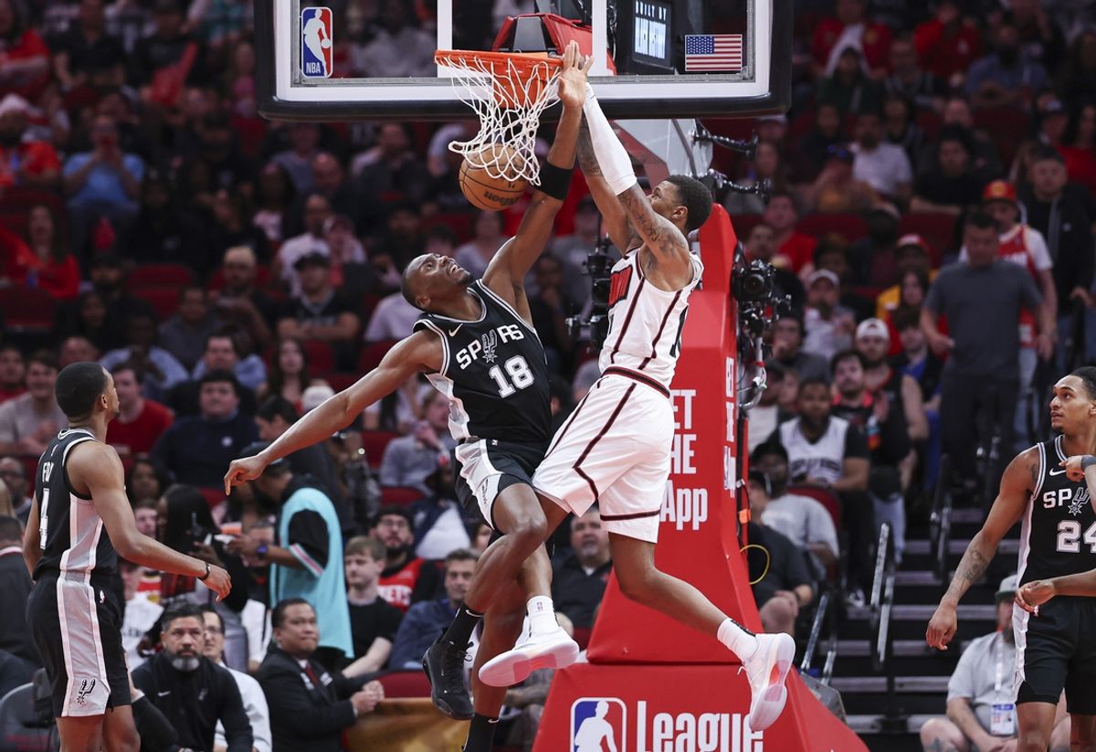 Feb 26, 2025; Houston, Texas, USA; Houston Rockets forward Jabari Smith Jr. (10) dunks the ball as San Antonio Spurs center Bismack Biyombo (18) defends during the first quarter at Toyota Center. Mandatory Credit: Troy Taormina-Imagn Images