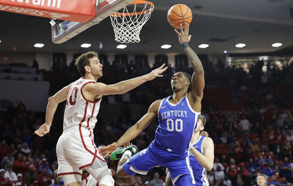 Feb 26, 2025; Norman, Oklahoma, USA; Kentucky Wildcats guard Otega Oweh (00) goes up for a shot as Oklahoma Sooners forward Sam Godwin (10) defends during the first half at Lloyd Noble Center. Mandatory Credit: Alonzo Adams-Imagn Images
