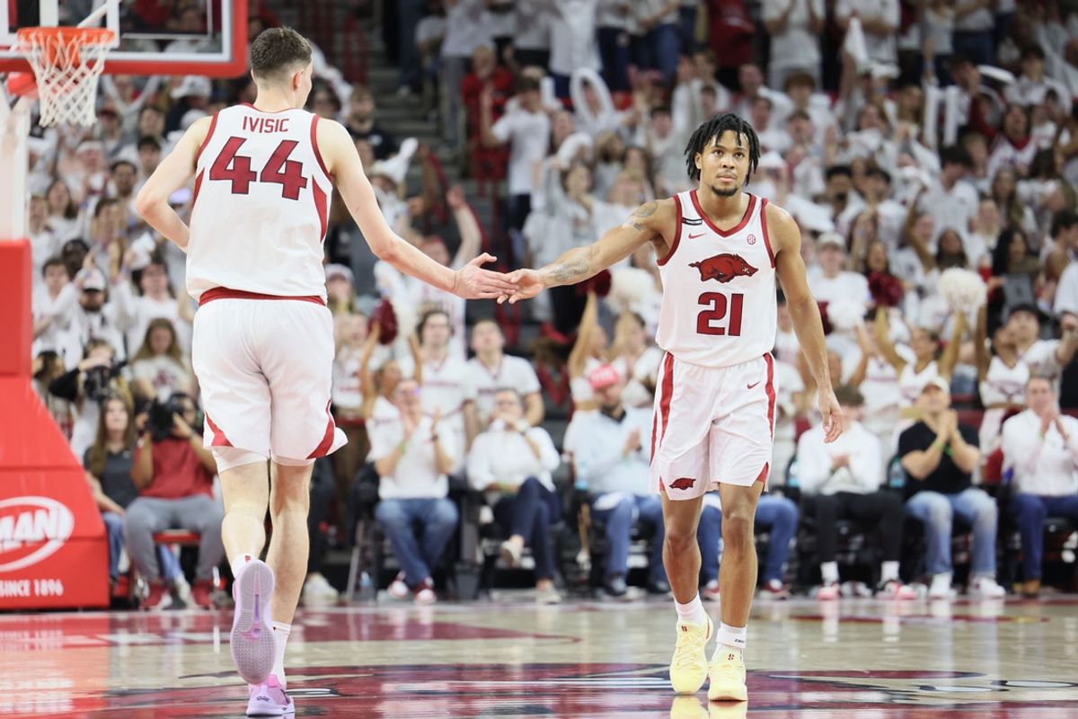 Feb 26, 2025; Fayetteville, Arkansas, USA; Arkansas Razorbacks guard D.J. Wagner (21) celebrates with forward Zvonimir Ivisic (44) after making a three-point shot in the first half against the Texas Longhorns at Bud Walton Arena. Mandatory Credit: Nelson Chenault-Imagn Images