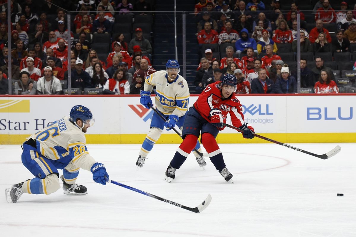 Feb 27, 2025; Washington, District of Columbia, USA; Washington Capitals center Dylan Strome (17) passes the puck as St. Louis Blues left wing Nathan Walker (26) defends in the first period at Capital One Arena. Mandatory Credit: Geoff Burke-Imagn Images