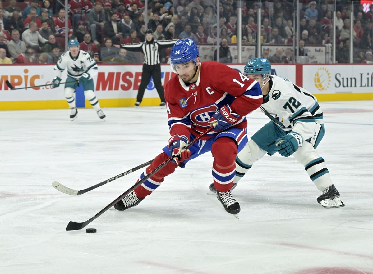 Feb 27, 2025; Montreal, Quebec, CAN; Montreal Canadiens forward Nick Suzuki (14) plays the puck and San Jose Sharks forward William Eklund (72) defends during the first period at the Bell Centre. Mandatory Credit: Eric Bolte-Imagn Images