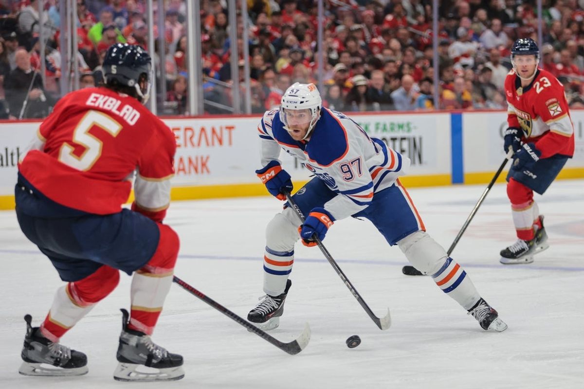 Feb 27, 2025; Sunrise, Florida, USA; Edmonton Oilers center Connor McDavid (97) moves the puck as Florida Panthers defenseman Aaron Ekblad (5) defends during the first period at Amerant Bank Arena. Mandatory Credit: Sam Navarro-Imagn Images