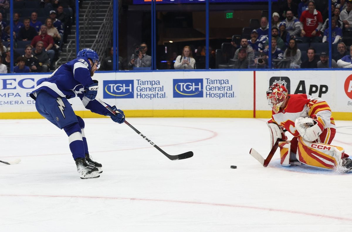 Feb 27, 2025; Tampa, Florida, USA; Tampa Bay Lightning left wing Brandon Hagel (38) shoots as Calgary Flames goaltender Dustin Wolf (32) makes a save during the first period at Amalie Arena. Mandatory Credit: Kim Klement Neitzel-Imagn Images