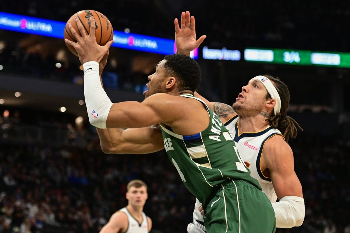 Feb 27, 2025; Milwaukee, Wisconsin, USA; Milwaukee Bucks forward Giannis Antetokounmpo (34) takes a shot against Denver Nuggets forward Aaron Gordon (32) in the first quarter at Fiserv Forum. Mandatory Credit: Benny Sieu-Imagn Images