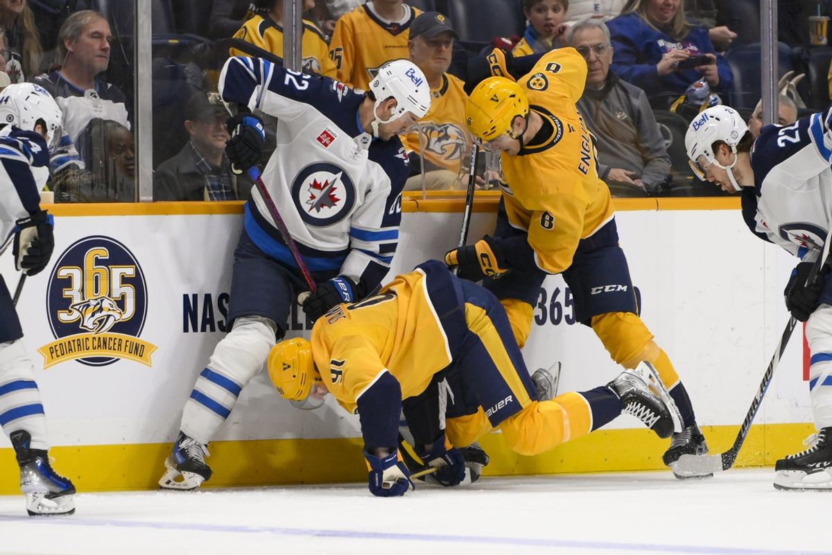 Feb 27, 2025; Nashville, Tennessee, USA;  Winnipeg Jets right wing Nino Niederreiter (62) battles for the puck with Nashville Predators center Steven Stamkos (91) and defenseman Andreas Englund (8) during the second period at Bridgestone Arena. Mandatory Credit: Steve Roberts-Imagn Images