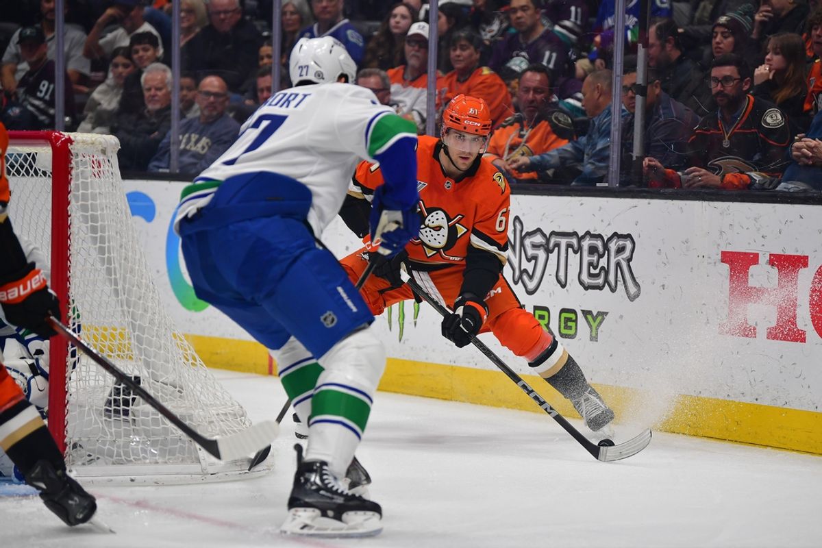 Feb 27, 2025; Anaheim, California, USA; Anaheim Ducks left wing Cutter Gauthier (61) controls the puck against Vancouver Canucks defenseman Derek Forbort (27) during the second period at Honda Center. Mandatory Credit: Gary A. Vasquez-Imagn Images